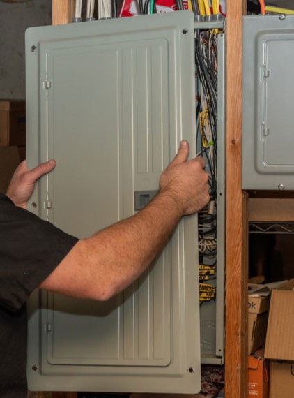 Black Diamond Experts technician opens an electrical panel, part of routine inspection and maintenance of electrical panels.