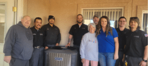 Our team taking a picture after replacing an HVAC system for free for a community member