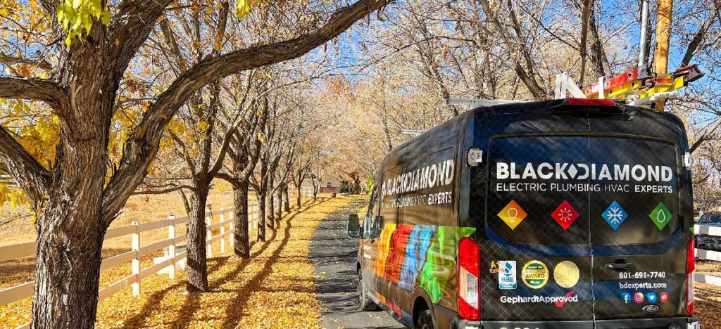 A Black Diamond Experts van on a leaf-strewn driveway, symbolizing 24/7 trusted home comfort and repair service in Utah.