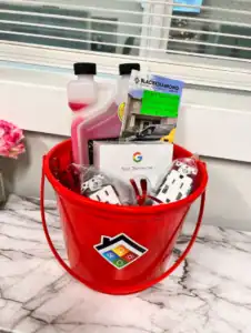 A welcoming red bucket with helpful brochures, a Google Nest thermostat, and home essentials sits ready for trusted 24/7 Black Diamond care.