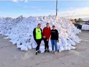 Three team members stand by a stack of sandbags, ready to provide Utah homes with trusted 24/7 plumbing, HVAC, and electrical help.