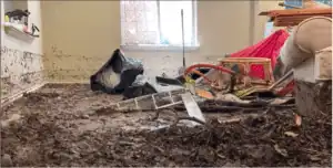 A flood-damaged room with mud, debris, and broken furniture—trust Black Diamond Experts for 24/7 recovery and lasting comfort.