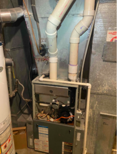 A residential furnace with visible wiring and pipes, expertly installed near a water heater by trusted Utah home service professionals.