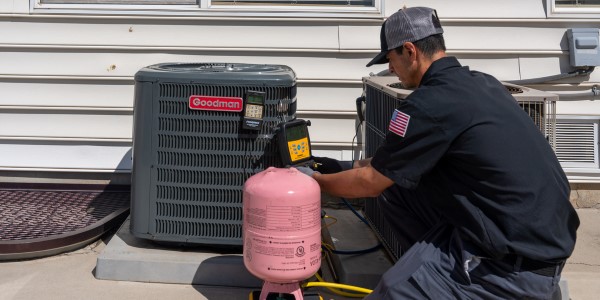 A skilled Black Diamond Experts technician services an outdoor Goodman HVAC unit with care, ensuring your Utah home’s comfort and safety—24/7.