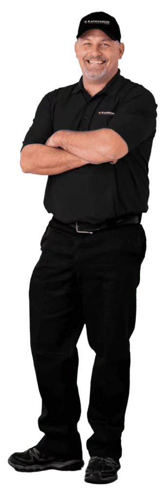 A friendly technician in a Black Diamond Experts uniform stands confidently, representing expert 24/7 home repair and comfort services.
