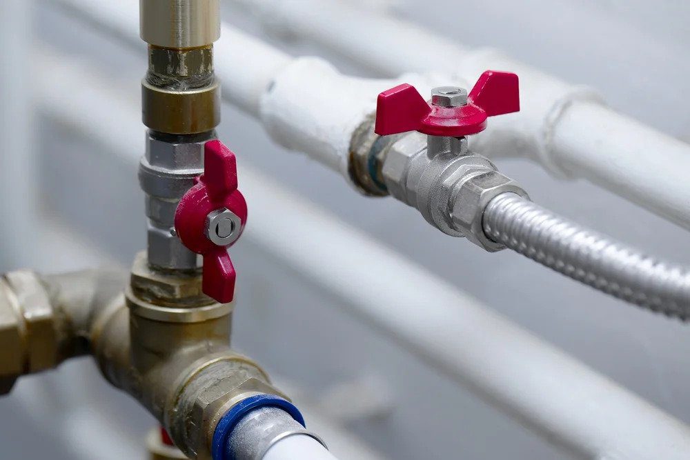 A detailed view of sturdy plumbing pipes and red-handled valves, installed with expert care by Utah’s trusted 24/7 home service team.
