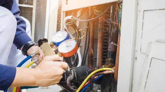A Black Diamond Experts technician checks refrigerant on an AC unit—delivering safe, reliable comfort and 24/7 home service in Utah.