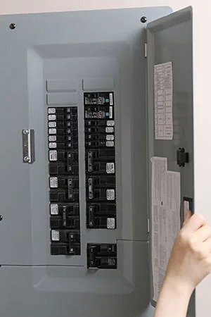 A skilled technician opens an electrical breaker panel, showcasing safe, reliable service from Utah’s trusted 24/7 home experts.
