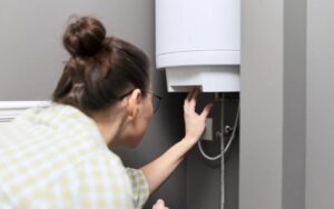 A technician checks a wall-mounted water heater, ensuring safe, reliable operation—24/7 peace of mind from trusted local experts.