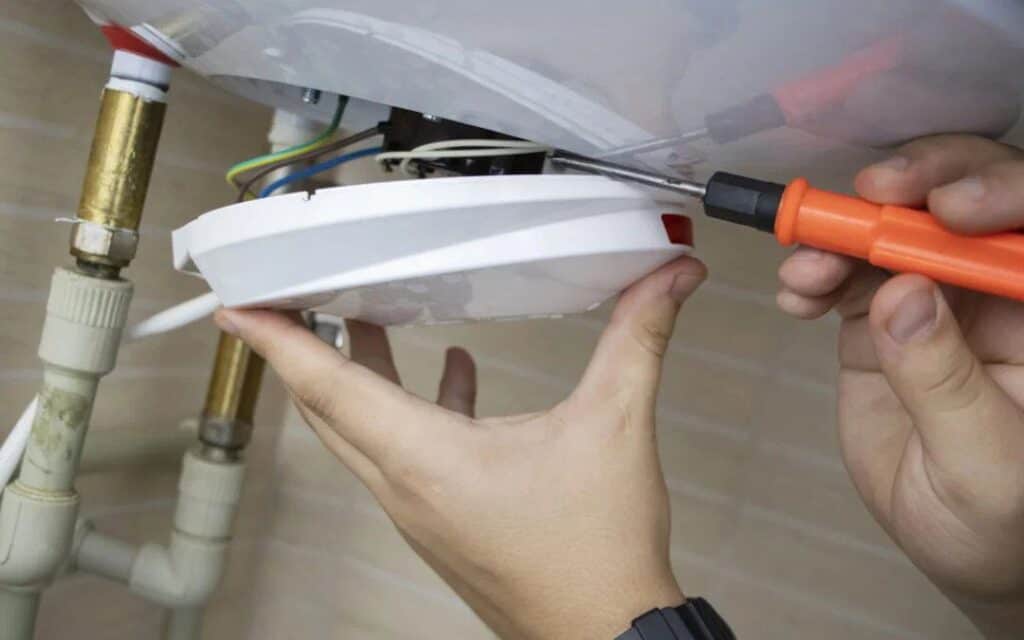 A skilled Black Diamond Experts technician safely repairs electrical wiring under a sink, ensuring reliable 24/7 home comfort.