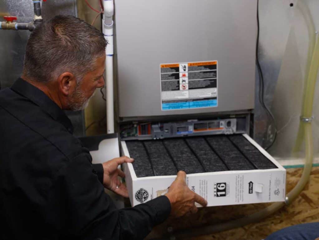 A skilled technician changes an HVAC air filter, ensuring safe, reliable comfort—Black Diamond Experts are Utah’s 24/7 home service pros.