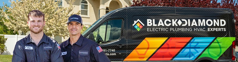 Two friendly Black Diamond Experts technicians stand by their service van, ready to provide trusted 24/7 HVAC, plumbing & electrical care.